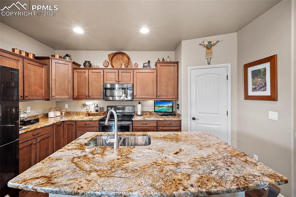 Image 11 of 39: Kitchen with an island with sink, appliances with stainless steel finishes,
