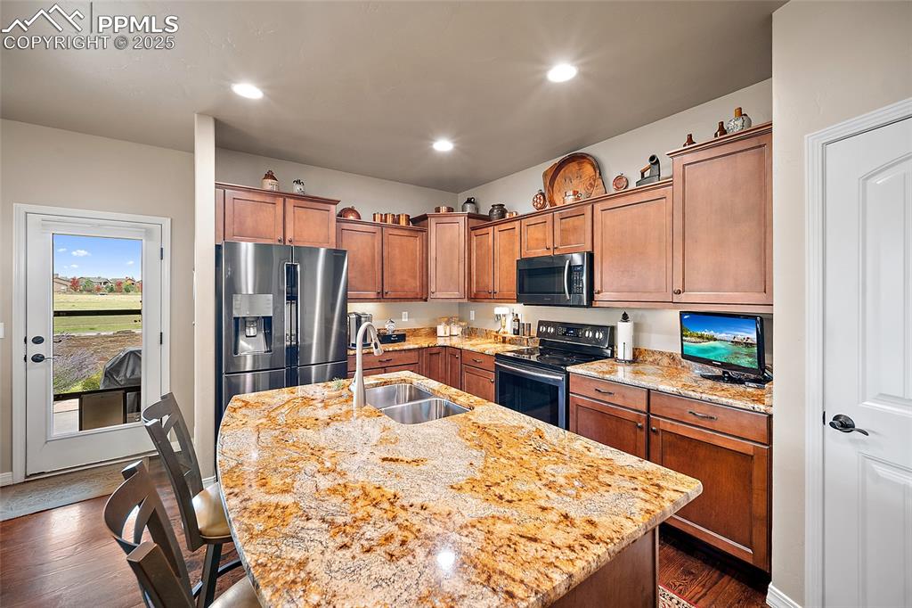 Image 12 of 39: Kitchen featuring electric stove, dark wood finished floors, stainless stee
