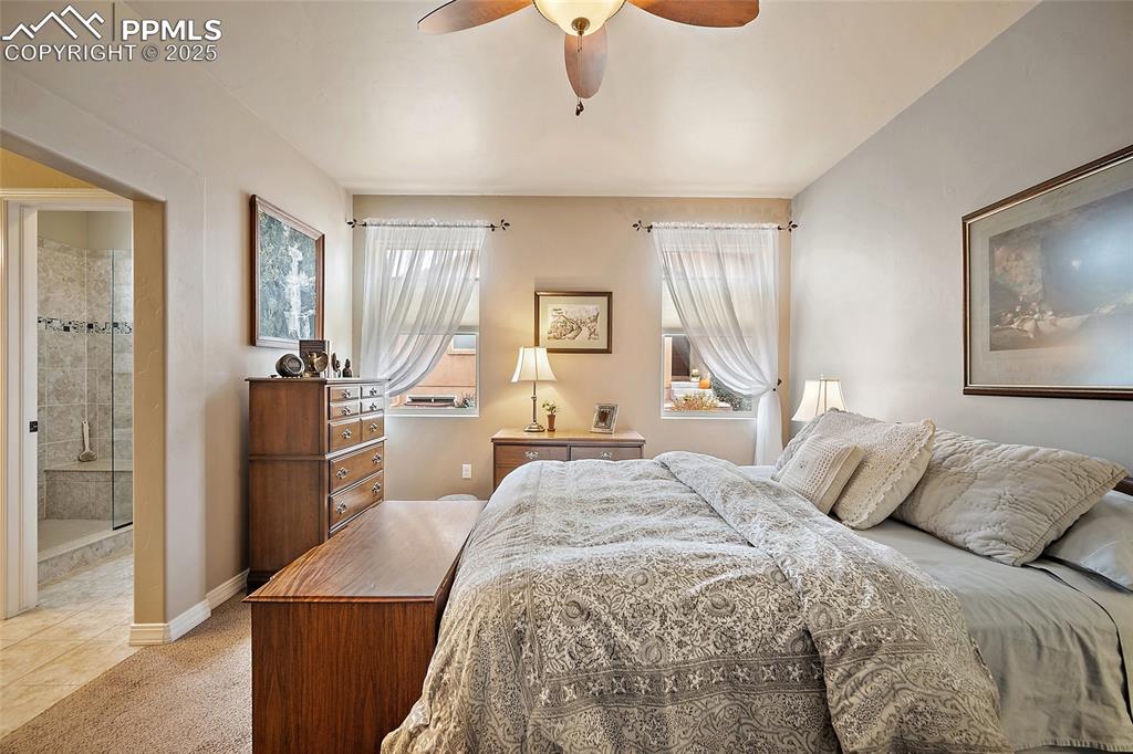 Image 16 of 39: Bedroom featuring a ceiling fan, light colored carpet, and light tile patte