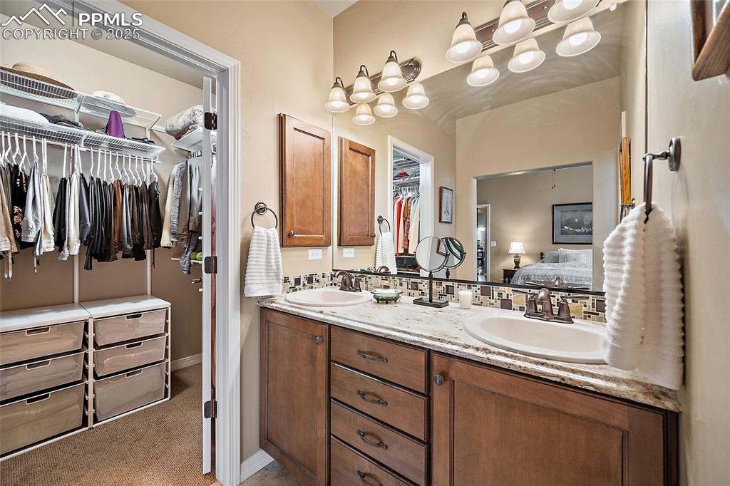 Image 19 of 39: Bathroom featuring a spacious closet, double vanity, light colored carpet, 