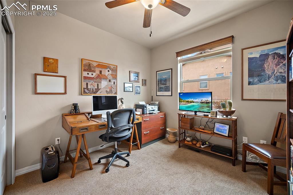 Image 20 of 39: Office with light carpet and a ceiling fan