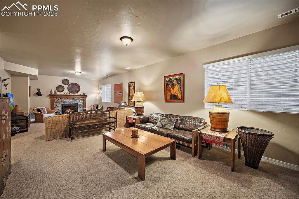 Image 24 of 39: Living area featuring a fireplace, carpet, and a textured ceiling