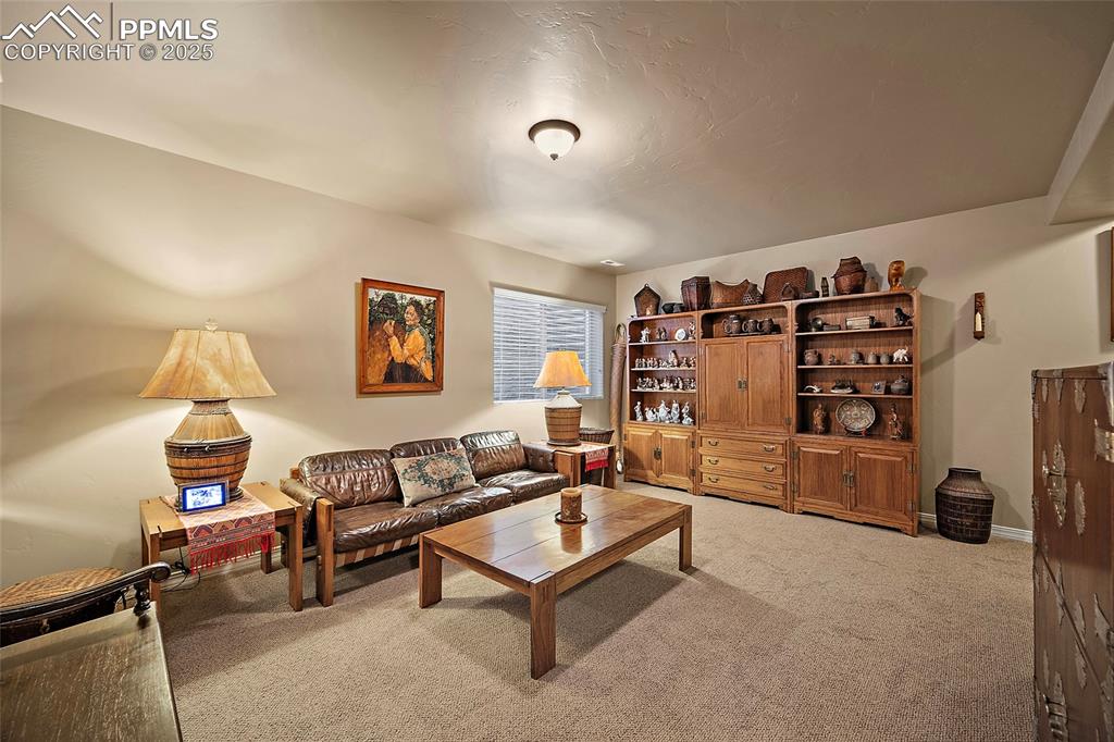 Image 26 of 39: Living area with light colored carpet and baseboards