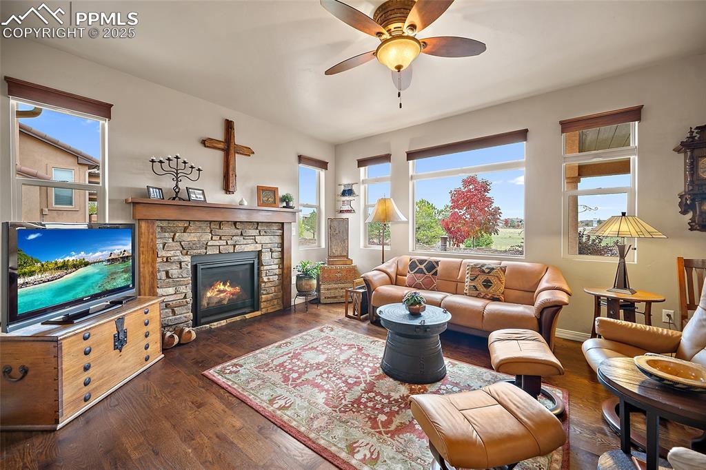 Image 6 of 39: Living area with dark wood-style flooring, a fireplace, healthy amount of n