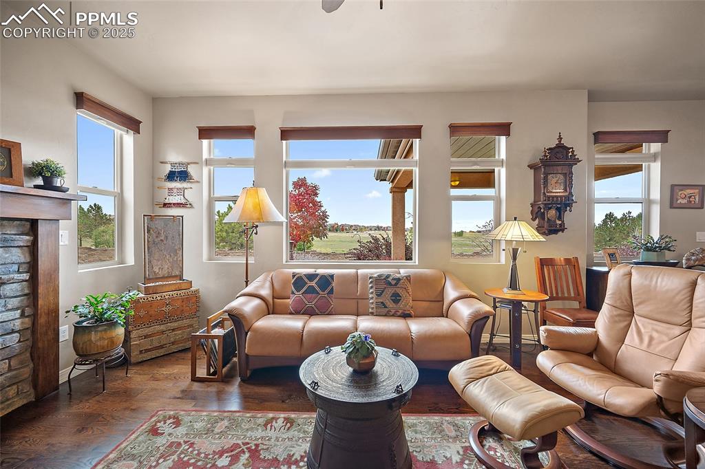 Image 7 of 39: Living area featuring wood finished floors, a fireplace, and ceiling fan