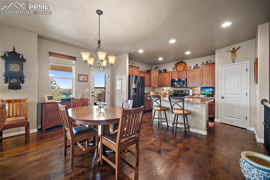 Image 9 of 39: Dining room with recessed lighting, dark wood finished floors, and a chande