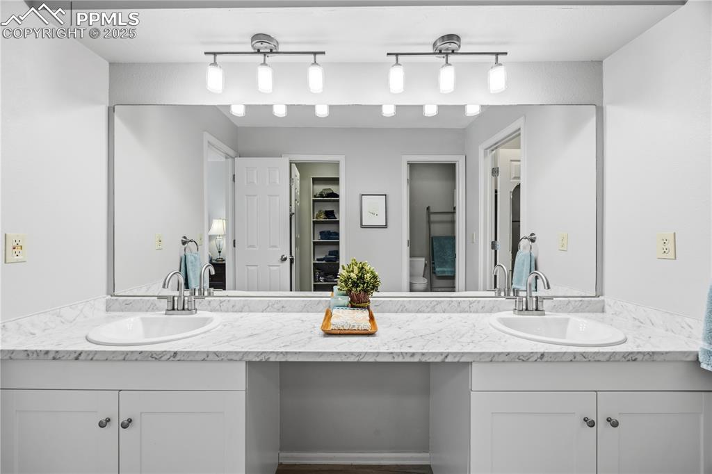Image 24 of 50: Full bathroom featuring double vanity and a spacious closet