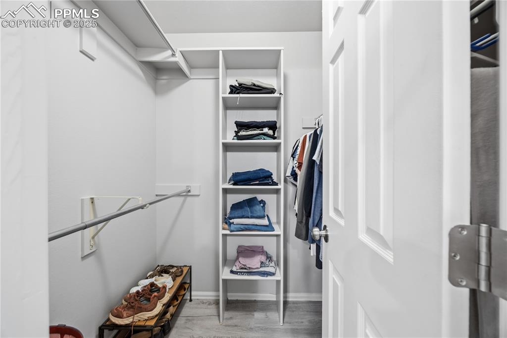 Image 26 of 50: Walk in closet featuring light wood-style flooring