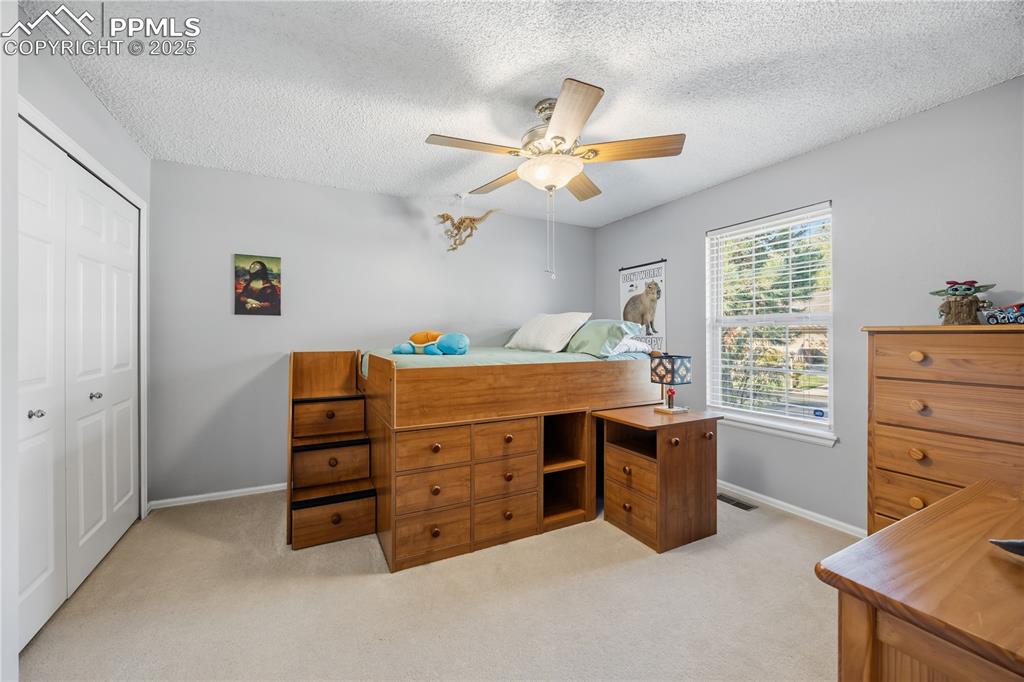 Image 30 of 50: Bedroom featuring a closet, light colored carpet, a ceiling fan, and a text