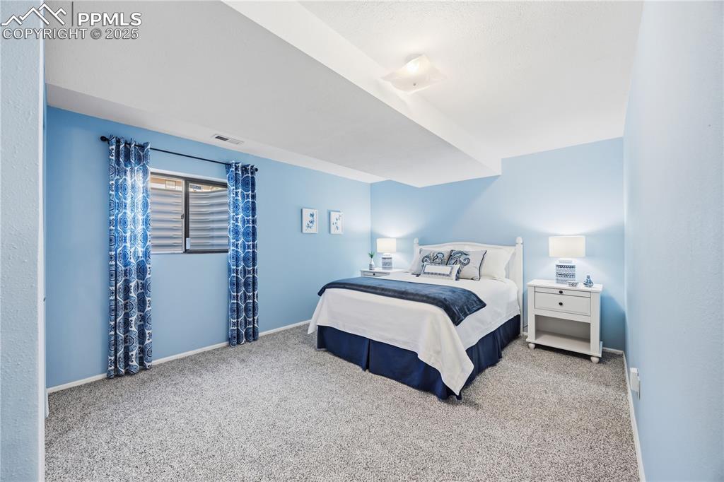 Image 32 of 50: Bedroom with carpet floors and baseboards