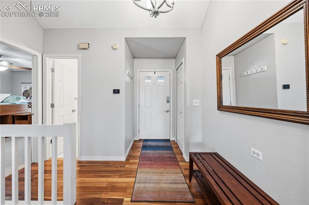 Image 5 of 50: Entryway with wood finished floors and a textured ceiling
