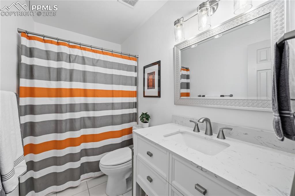 Image 7 of 50: Bathroom featuring a shower with curtain, vanity, and light tile patterned 