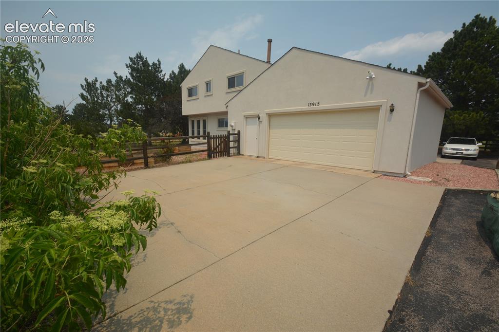 Image 1 of 45: Front side of drive through garage as you approach the home.