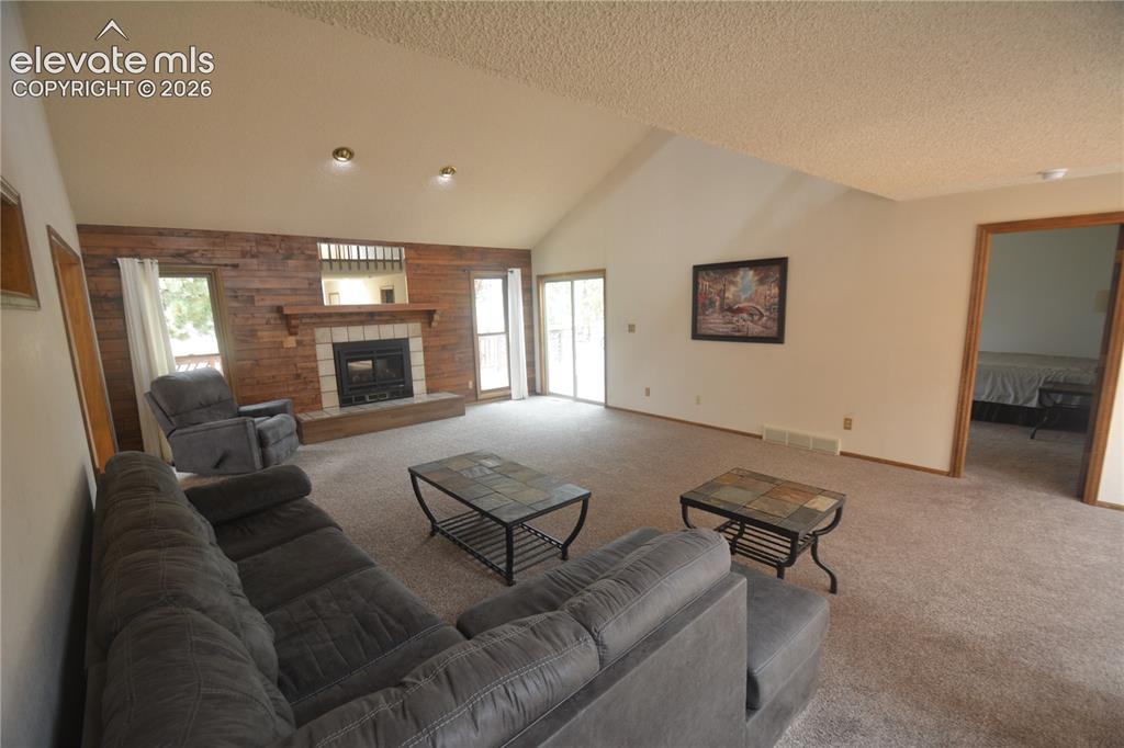 Image 14 of 45: view of living room looking toward walk-out and fireplace