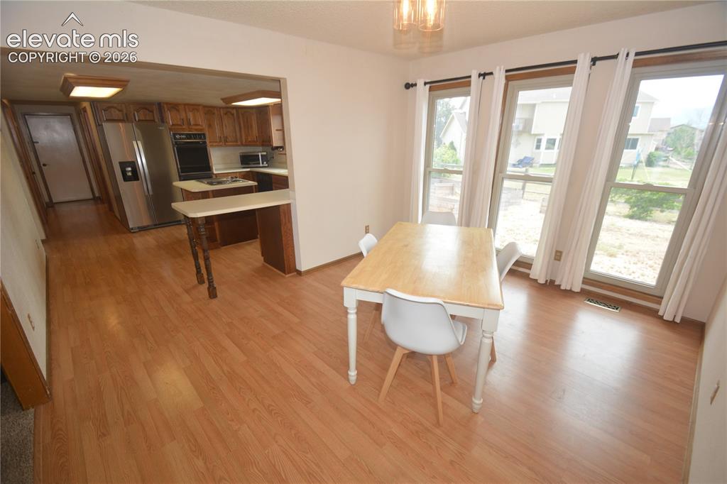 Image 15 of 45: View from Living room into dining room and kitchen