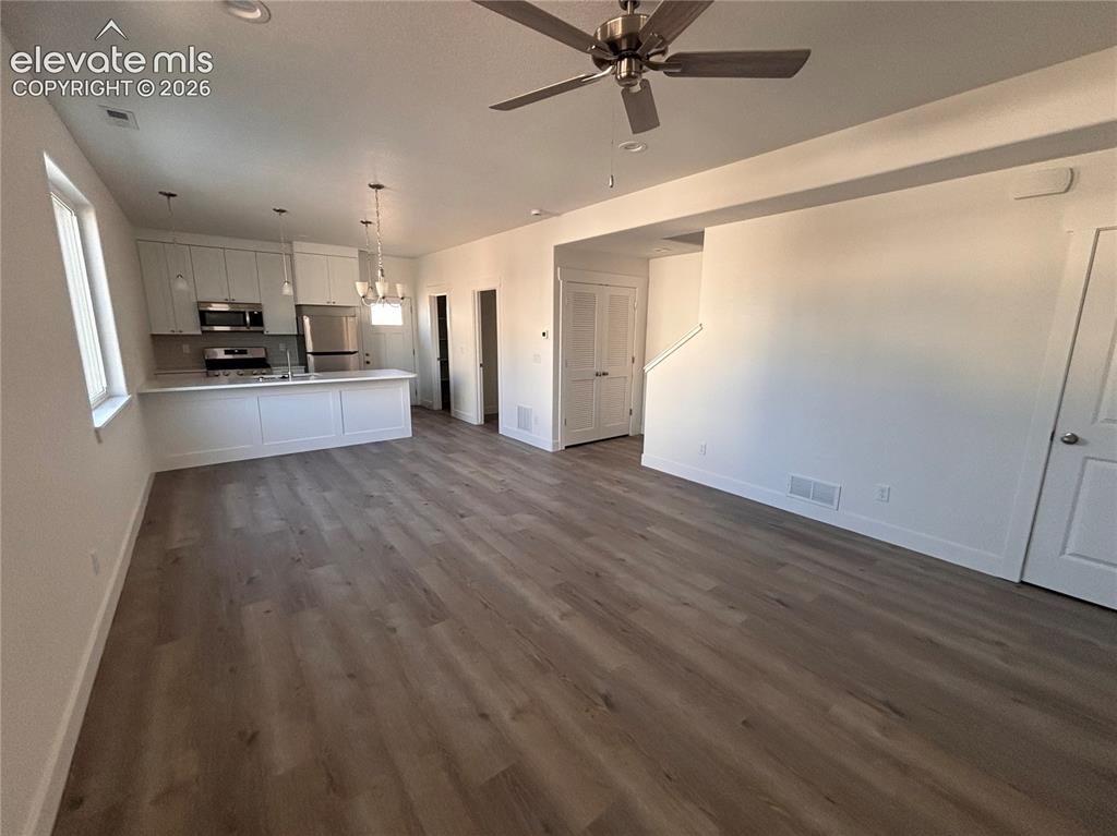 Image 2 of 17: Open-concept living space with wood-finish flooring, recessed lighting, and