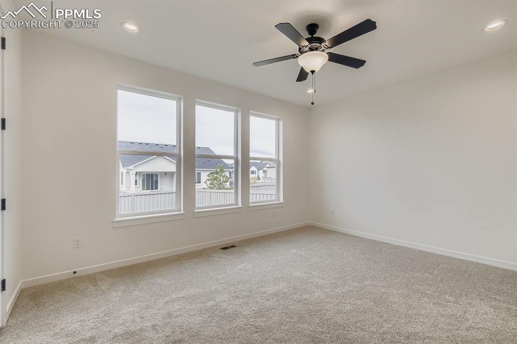 Image 11 of 28: Empty room with light colored carpet, recessed lighting, and ceiling fan