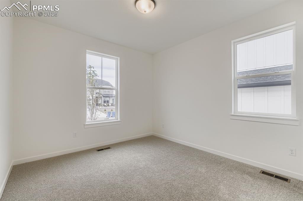 Image 16 of 28: Empty room featuring light colored carpet and healthy amount of natural lig