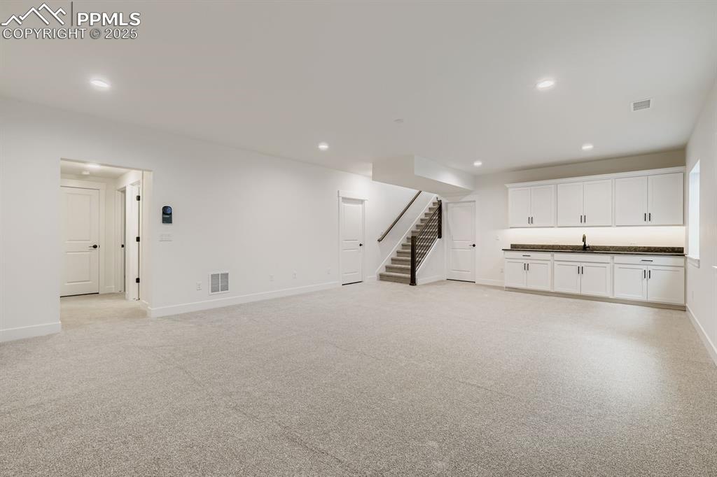 Image 18 of 28: Below grade area with stairway and recessed lighting