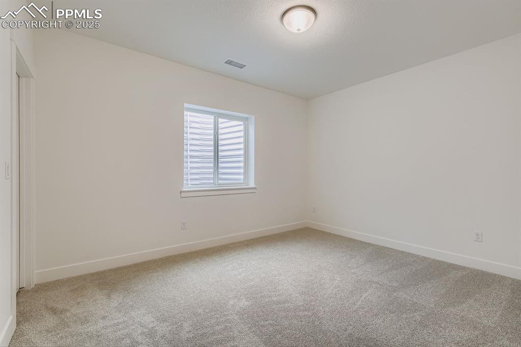 Image 22 of 28: Spare room featuring light carpet and baseboards