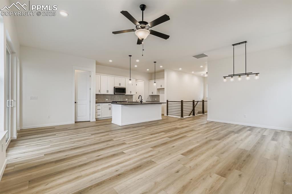 Image 6 of 28: Unfurnished living room featuring light wood-style flooring, a ceiling fan,