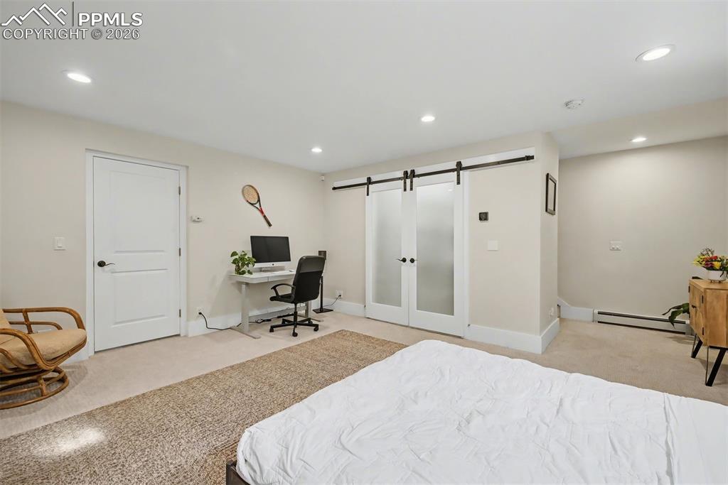 Image 32 of 43: Large walk in closet behind the sliding doors. Storage room beyond the othe