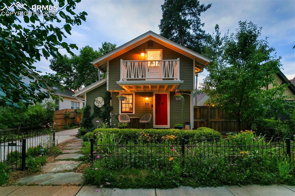 Image 35 of 43: Beautiful mature perennial gardens and wrought iron fence.