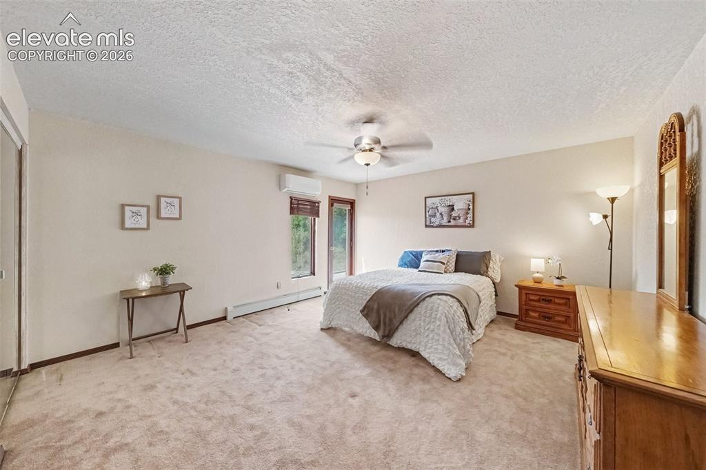 Image 13 of 44: Spacious first main-level primary bedroom offers a peaceful retreat with a