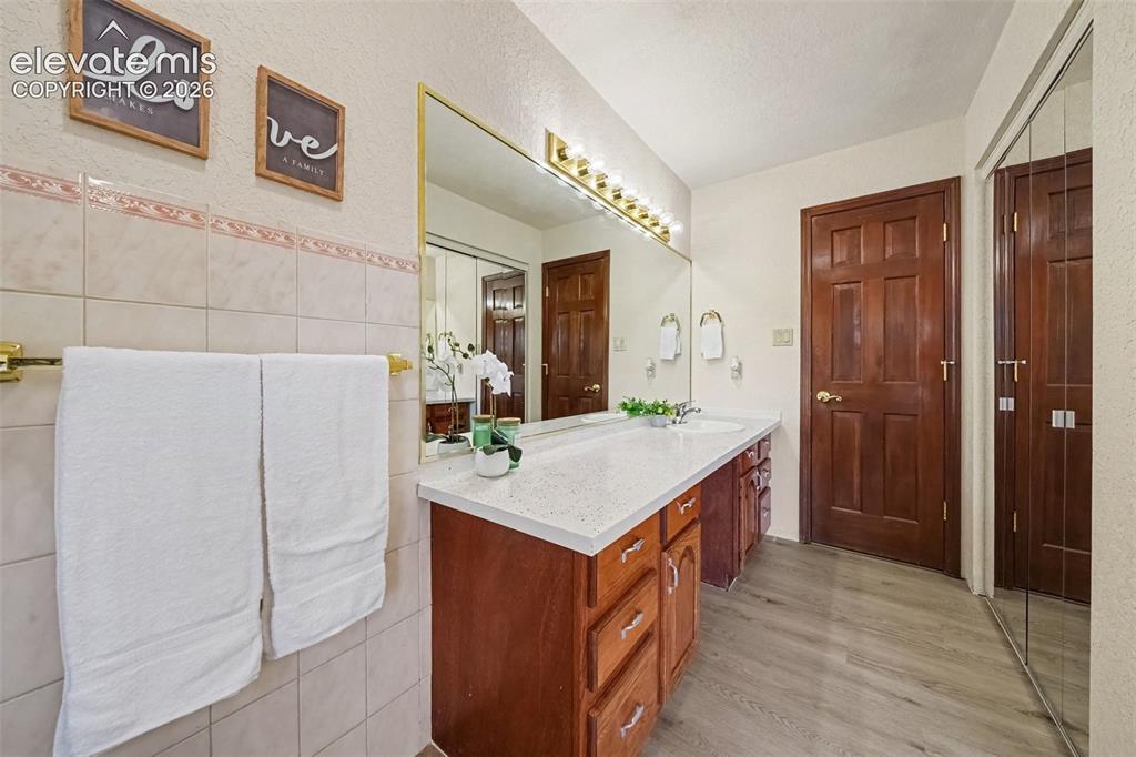 Image 14 of 44: Spacious main-level bathroom featuring a generous closet and a tub