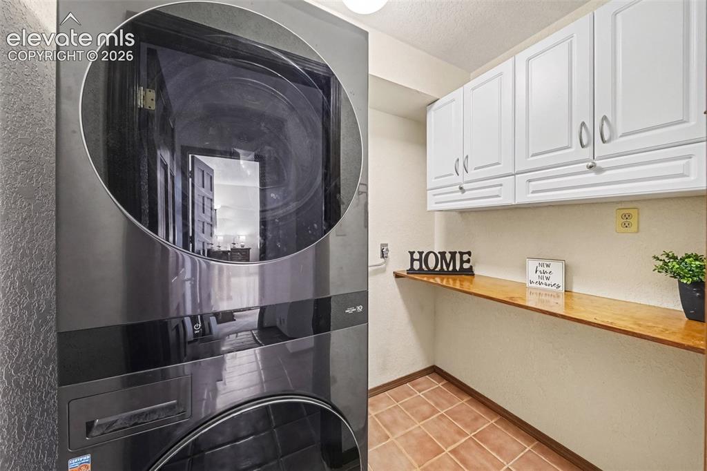 Image 16 of 44: Convenient main-level laundry room with ample cabinetry for storage and org