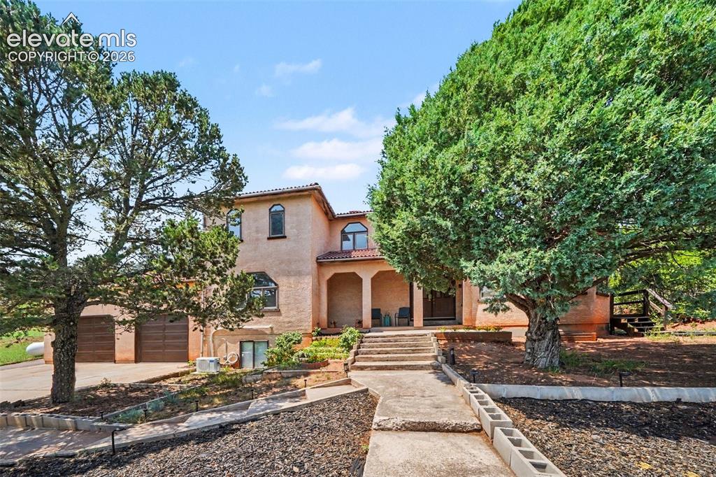 Image 2 of 44: Steps lead to the front door, surrounded by the beauty of the Red Rock Vall