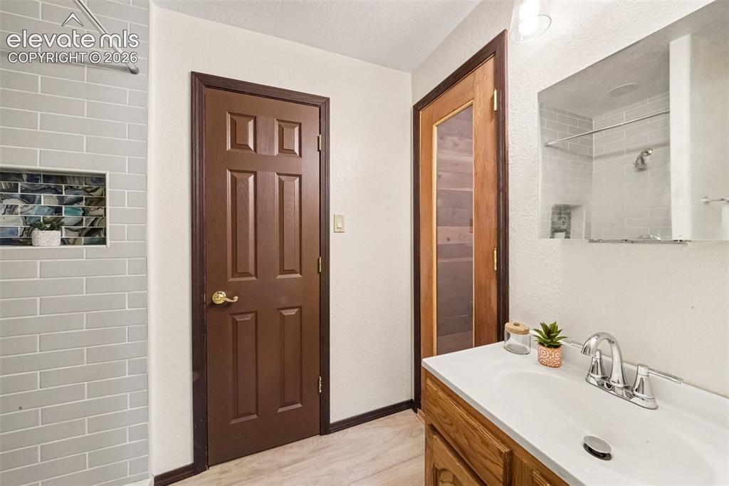 Image 23 of 44: Jack-and-Jill bathroom conveniently connects the basement bedroom and featu