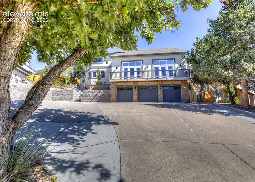 Image 2 of 50: Front of home with 3 car garage and lots of space for more vehicles and a c