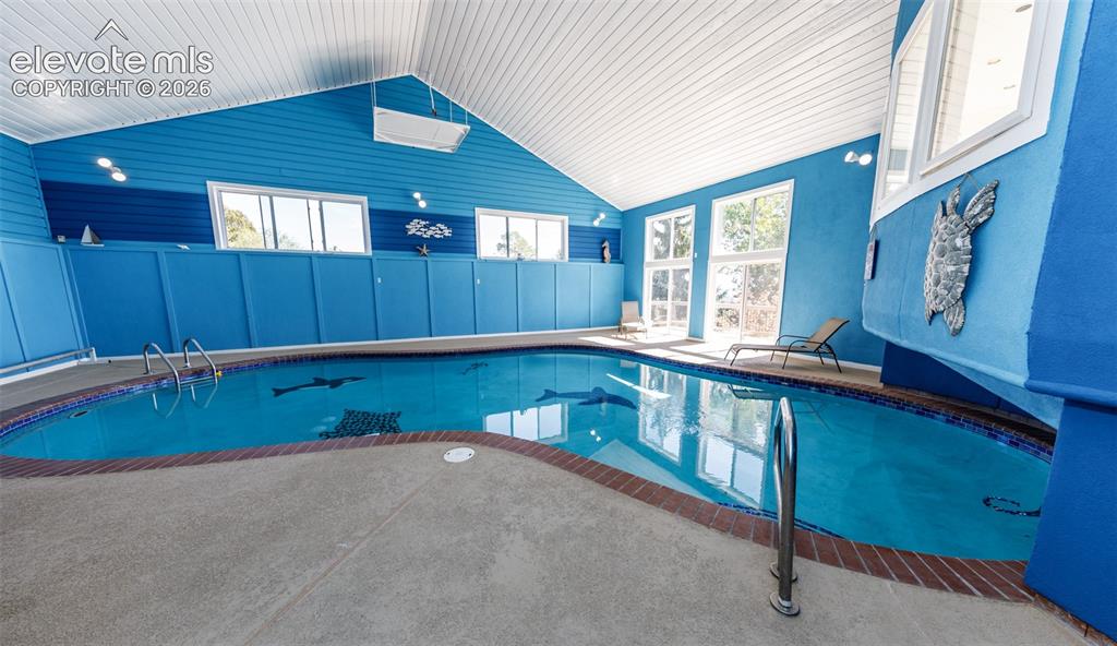 Image 36 of 50: Very Large indoor pool with 2 sliding glass doors to the outside upper deck