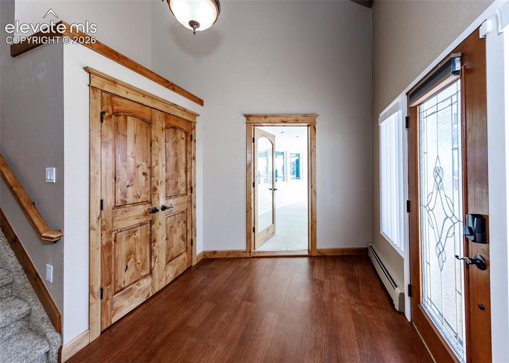 Image 5 of 50: Entry into home with large coat closet, large window and with hardwood floo