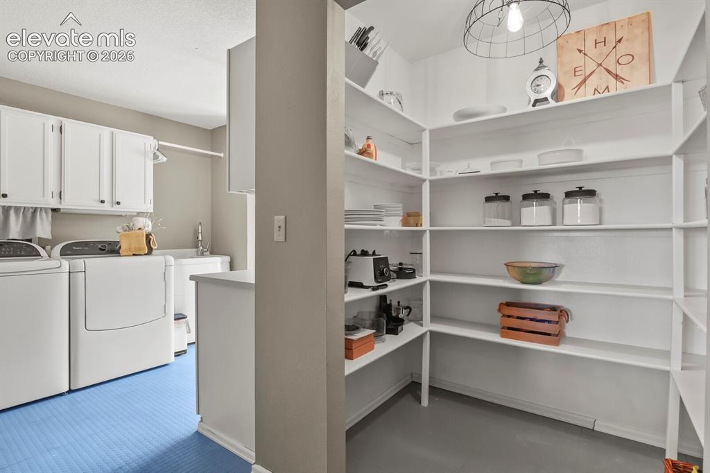 Image 18 of 41: Spacious walk-in pantry with abundant shelving, conveniently located near a