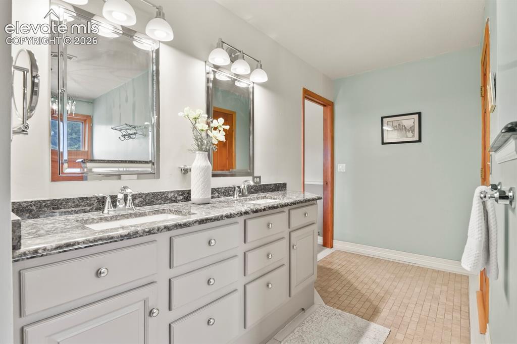 Image 22 of 41: Well-appointed primary bath with dual vanities, expansive counter space, an
