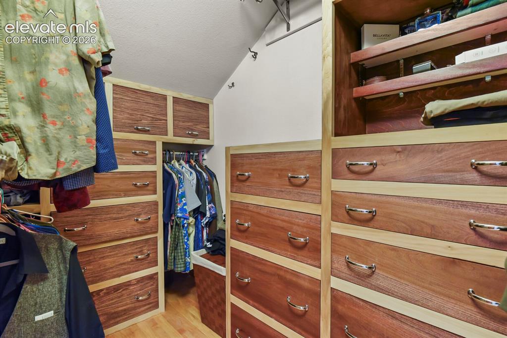 Image 24 of 41: Spacious Primary walk-in closet (one of two)  with custom built-ins, drawer