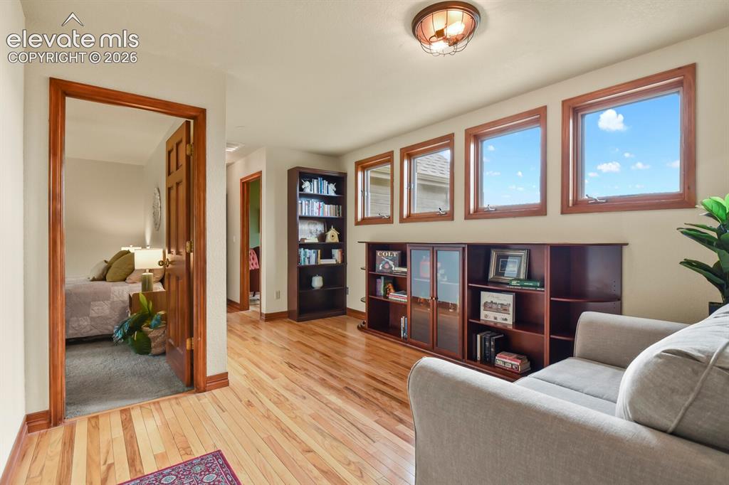 Image 27 of 41: Bright and versatile loft space featuring hardwood floors and a wall of win