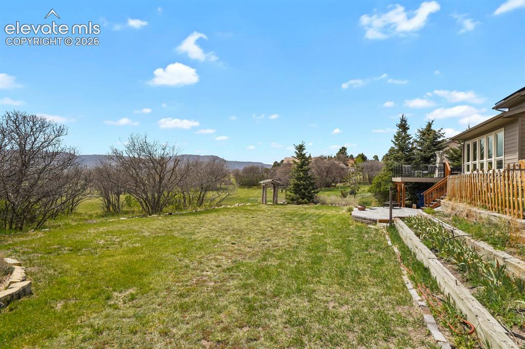 Image 35 of 41: Expansive backyard backing to open space with mountain views, featuring a n