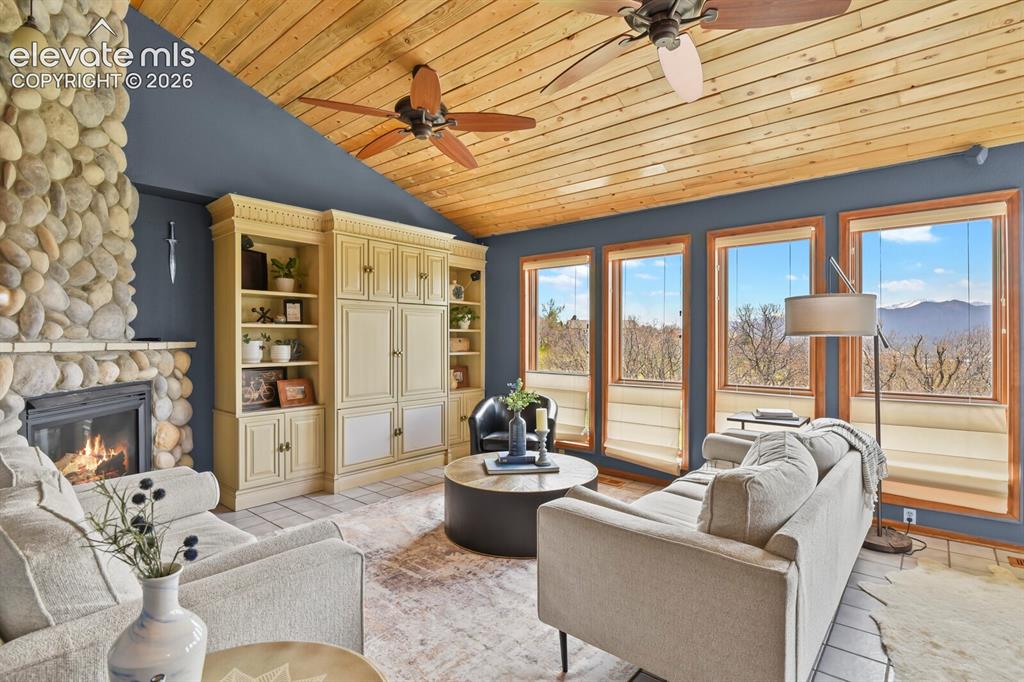 Image 9 of 41: Inviting family room with a wall of windows, beautiful wood ceilings, and a