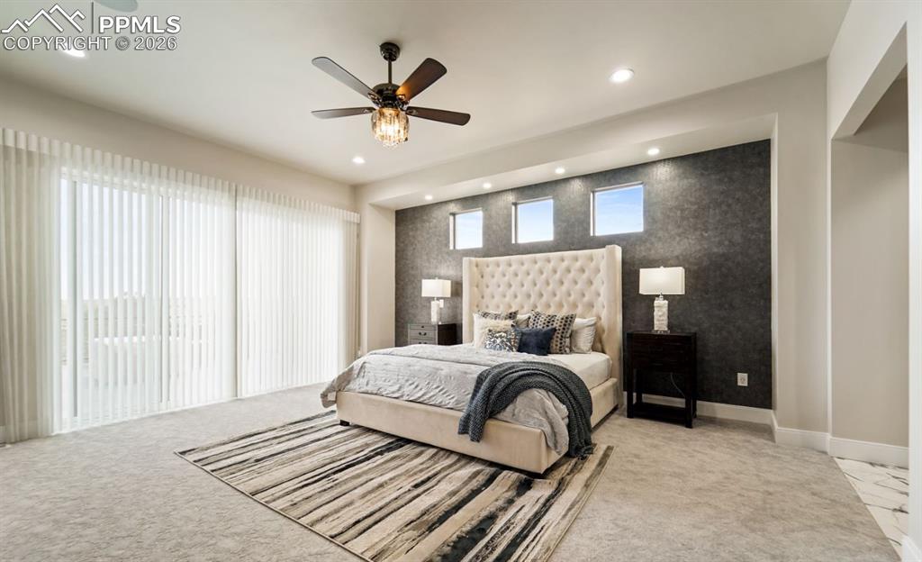 Image 17 of 50: This expansive first floor primary bedroom offers a walkout to the wrapping