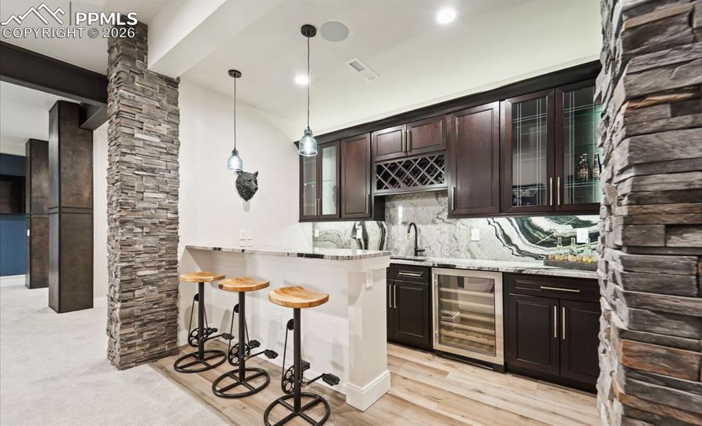 Image 40 of 50: Just outside the media room, this wet bar offers an easy stop for refreshme