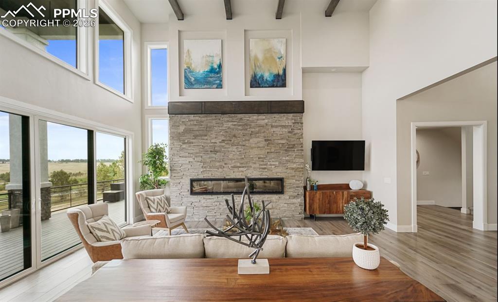 Image 7 of 50: Sliding door open to merge this grand room with the wrapping deck, creating