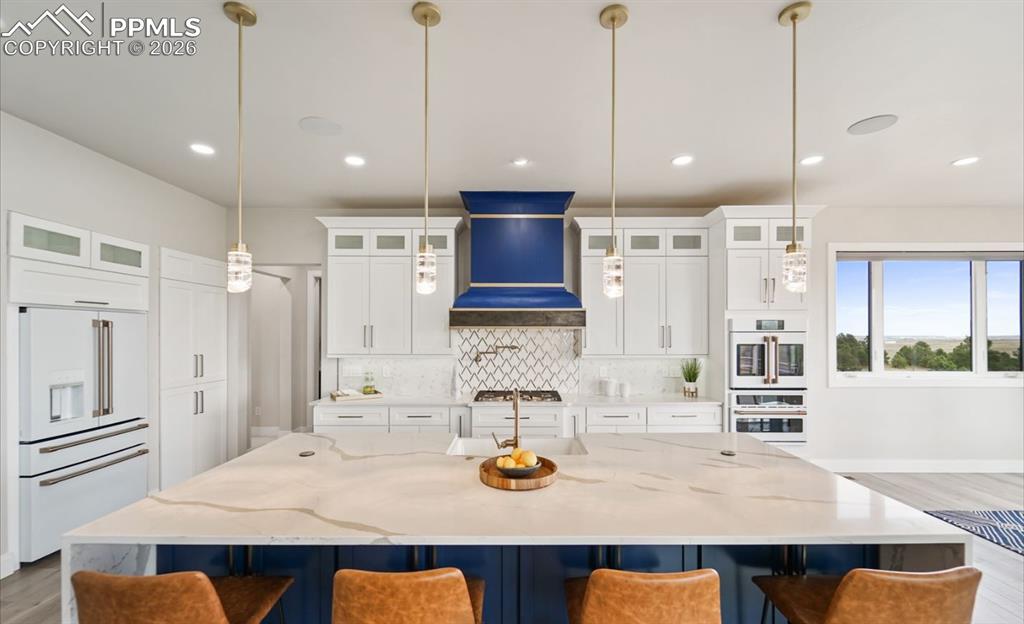 Image 8 of 50: Expansive breakfast bar features waterfall countertop. 