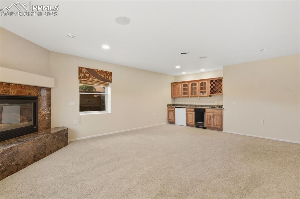 Image 37 of 50: Downstairs Family Room 2 of 2 with fireplace and wet bar kitchenette