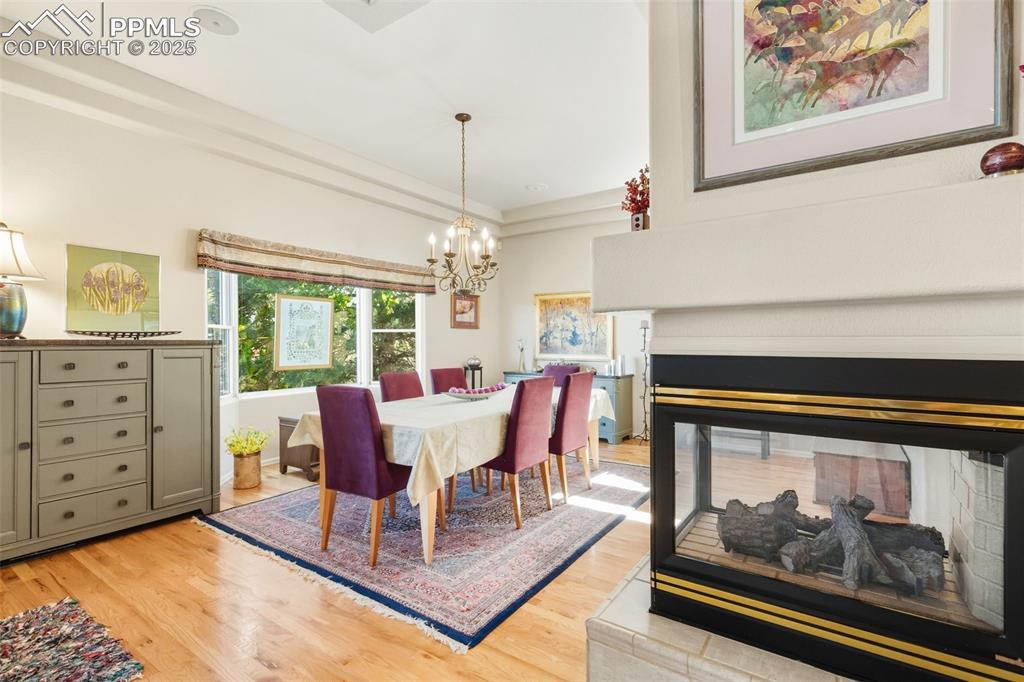 Image 9 of 50: Three sided fireplace between the Great Room and The dining room!
