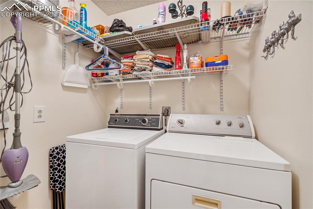 Image 27 of 37: Laundry is a room off the hall with storage shelves on both sides