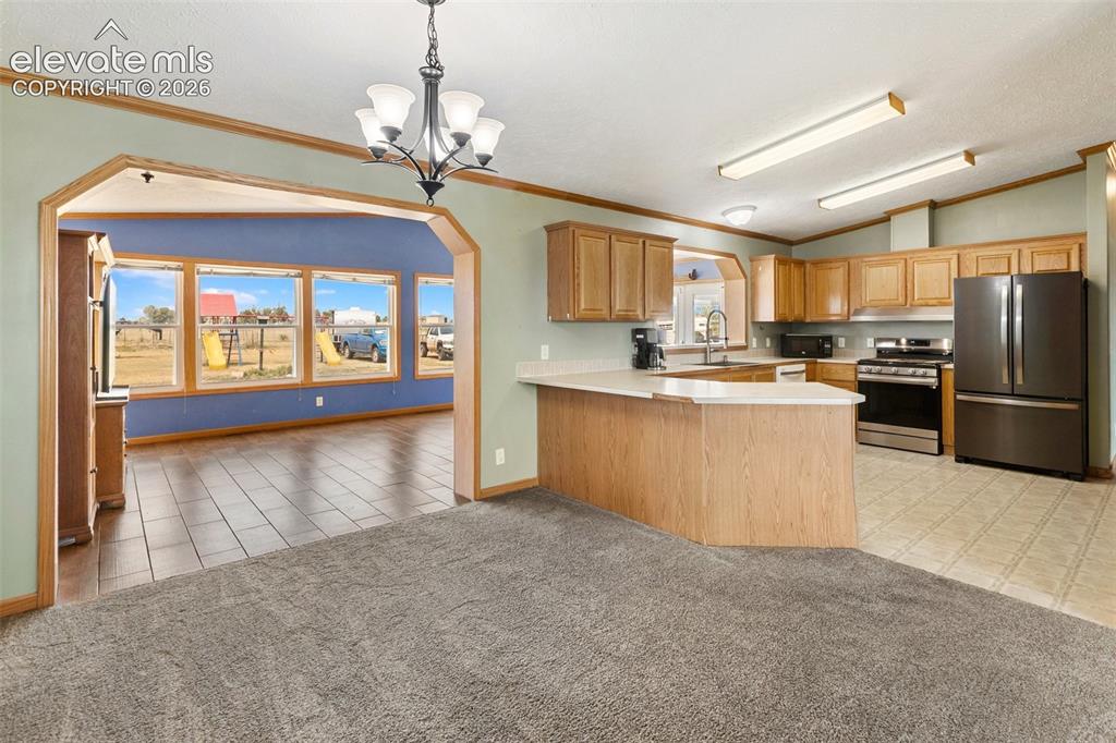 Image 18 of 45: Spacious kitchen featuring wood-finish cabinetry, stainless steel appliance