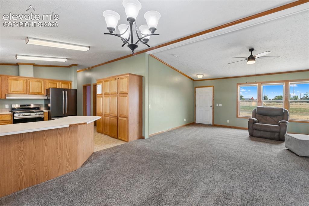Image 19 of 45: Open-concept living space featuring a kitchen with light wood cabinetry, a